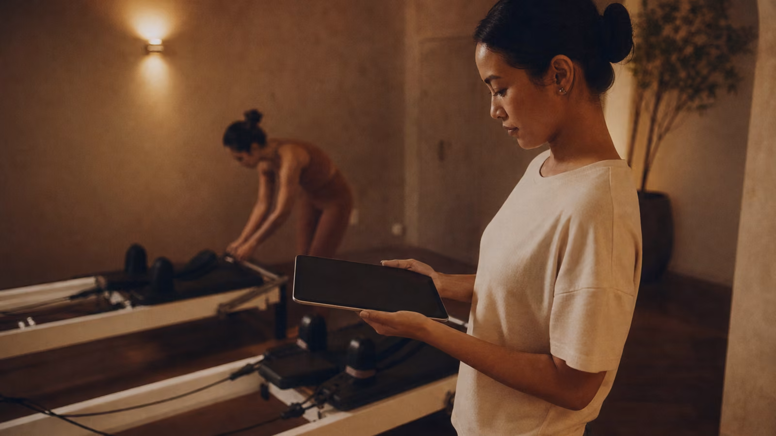Pemilik studio Pilates mengecek roster kelas di antara reformer